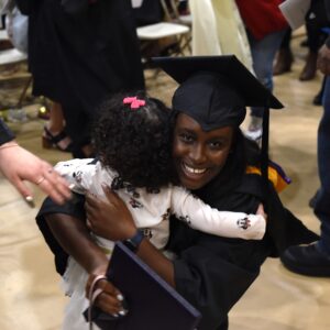 winter graduation, happy grad hugging their child.